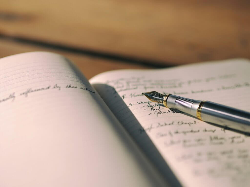 Un stylo plume posé sur un canet de notes.