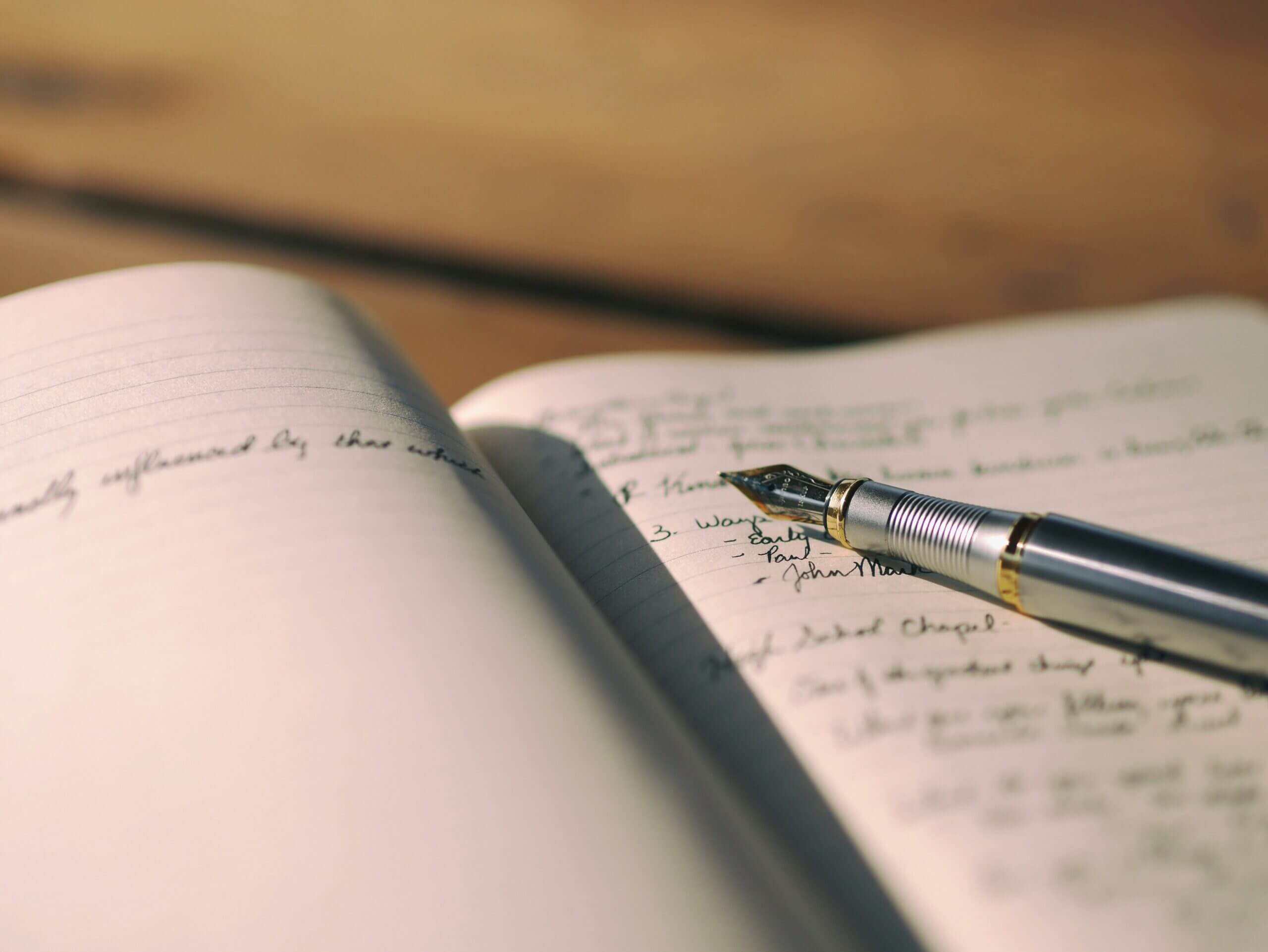 Un stylo plume posé sur un canet de notes.