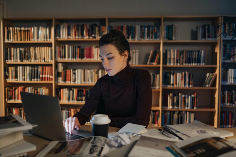 une jeune femme à la bibliothèque devant son pc