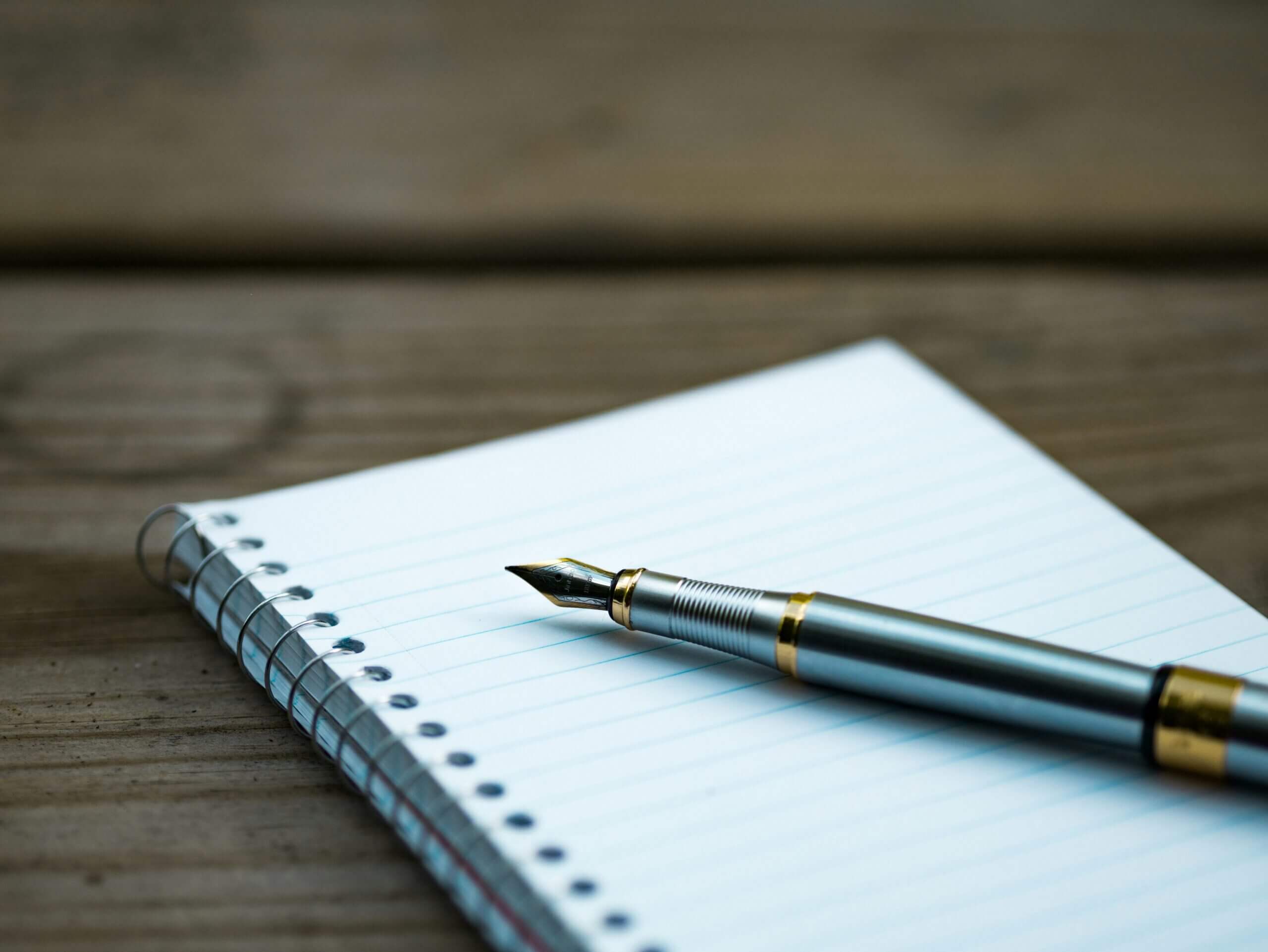 Un stylo posé dur un carnet vierge